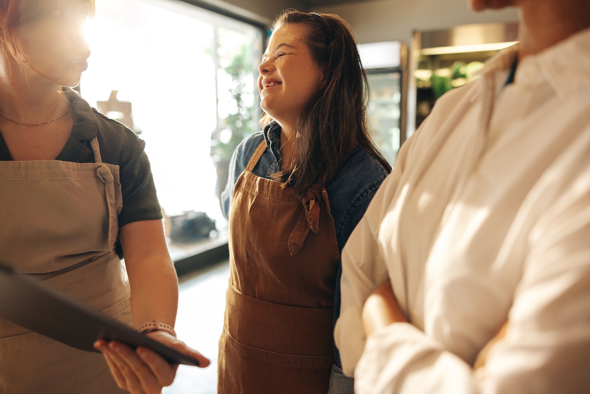 Woman with Down syndrome smiling during a staff meeting in a grocery store