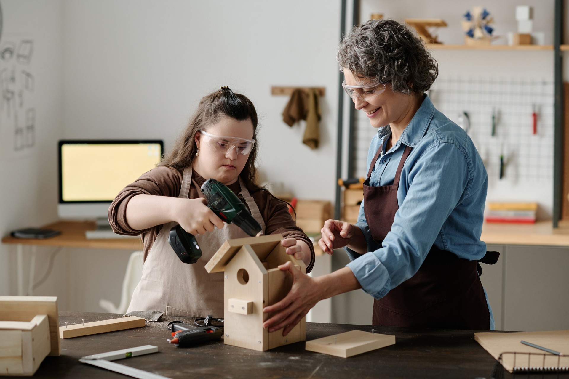 Girl with down syndrome making birdhouse